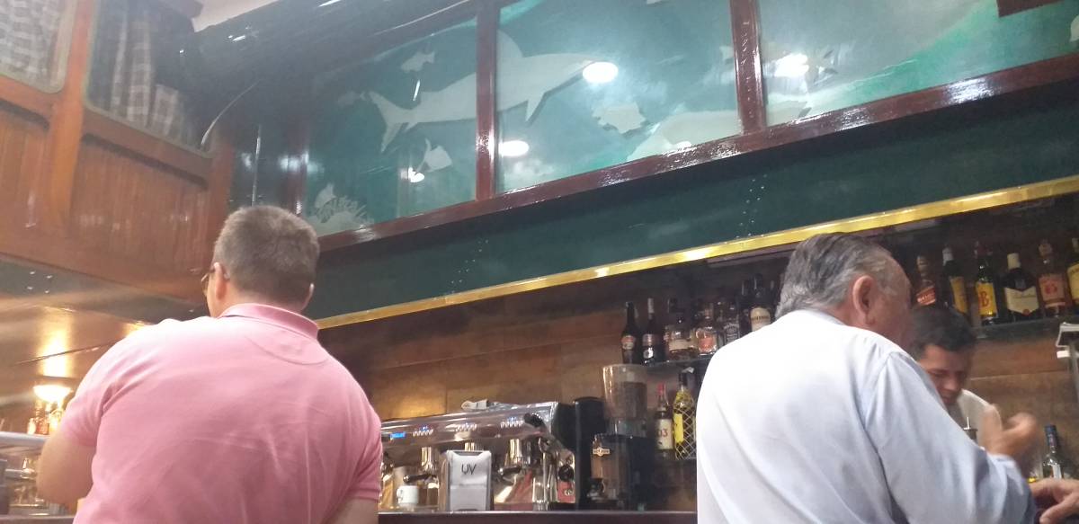 Dos clientes, acodados en la barra de Aquarium