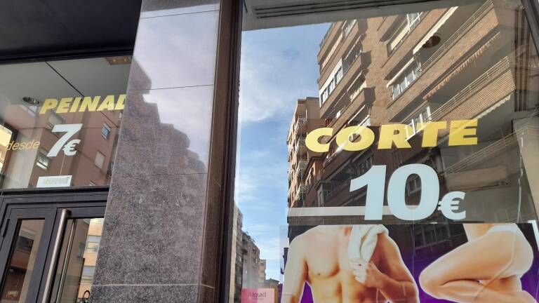 Entrada de una peluquería con los precios para sus clientes.