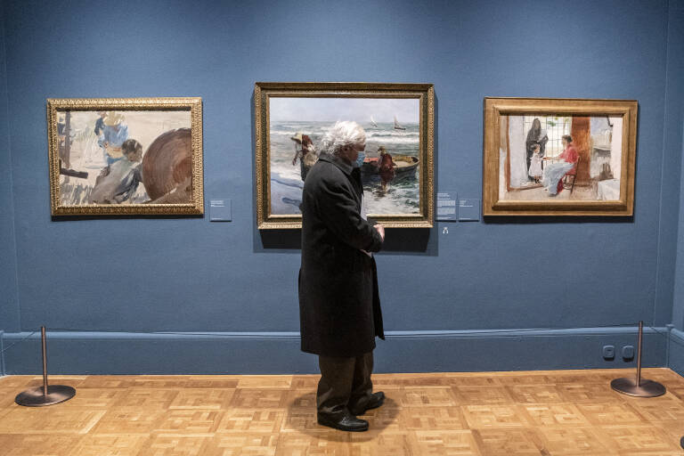 Un hombre delante de varias obras de Joaquín Sorolla en una exposición. Foto: A. PÉREZ MECA/EP