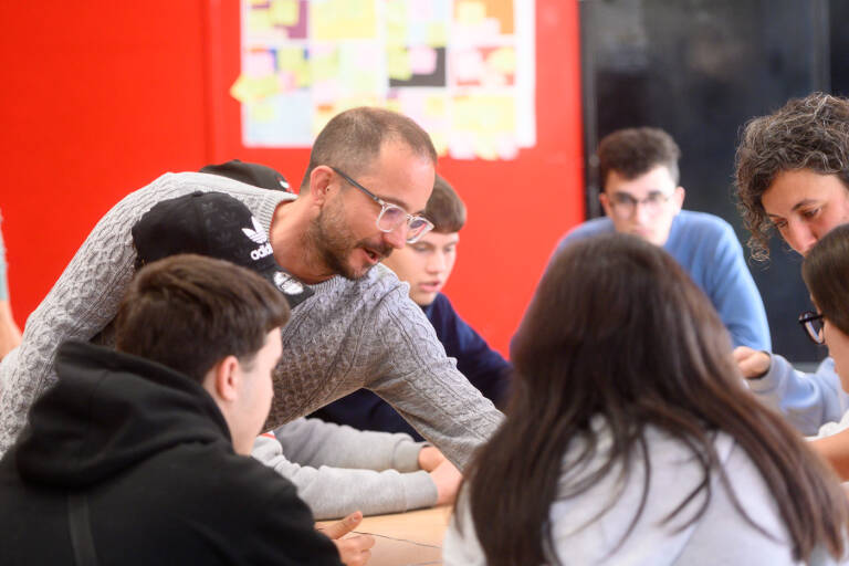 El coordinador psicopedagógico ayuda a los jóvenes en la resolución de una actividad. Foto: KIKE TABERNER