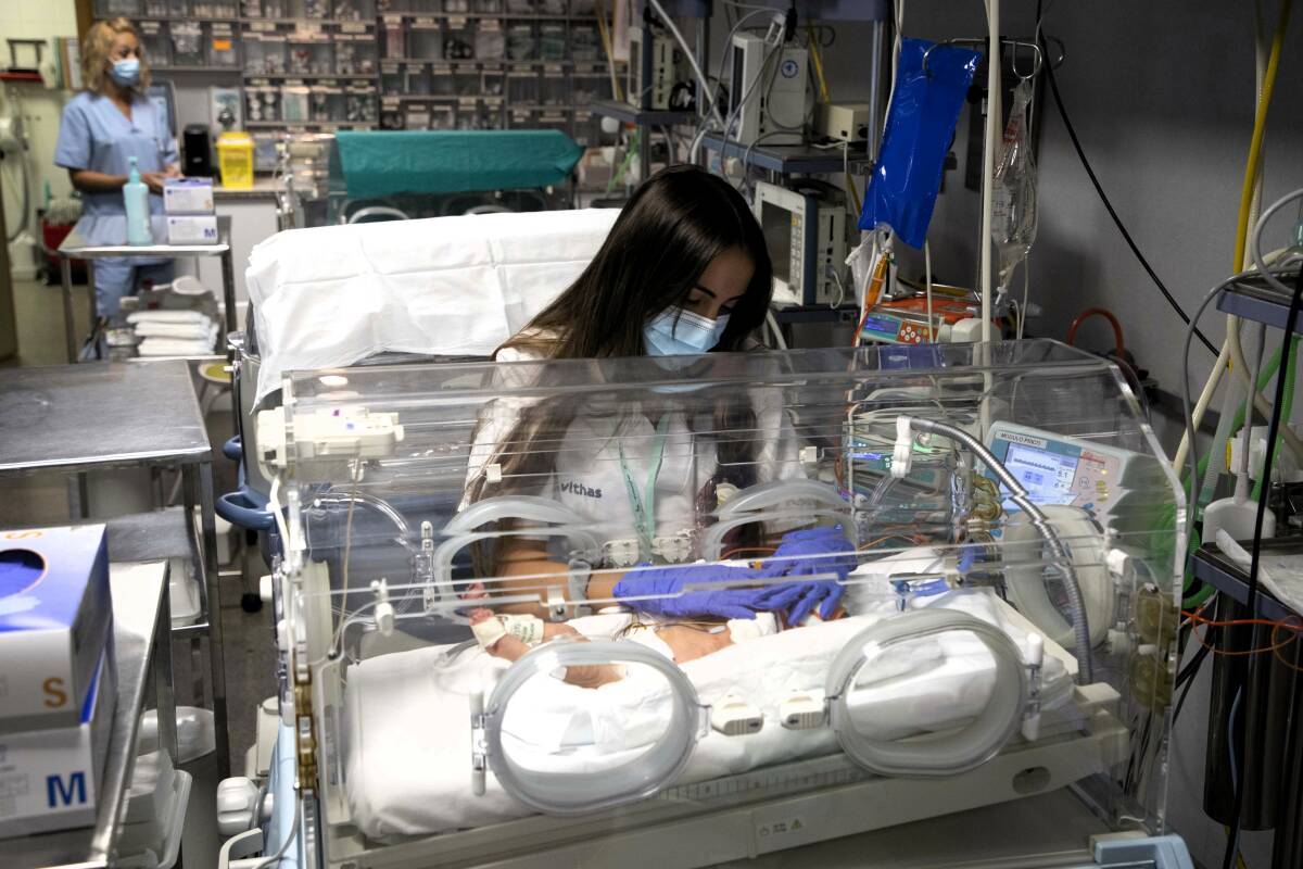 Enfermera en el servicio de UCI Pediátrica ocupándose de los cuidados de un neonato.